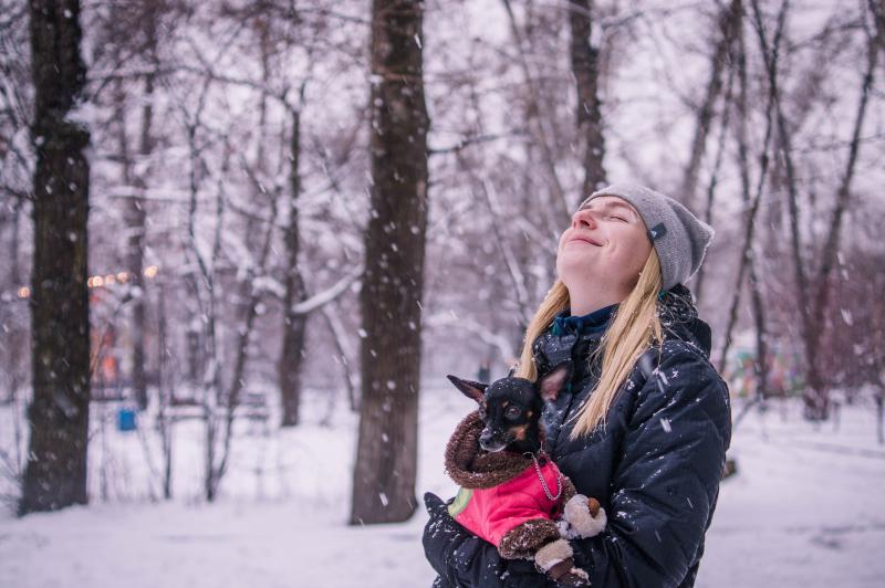 foto de una dueña cuidando de su perro en invierno